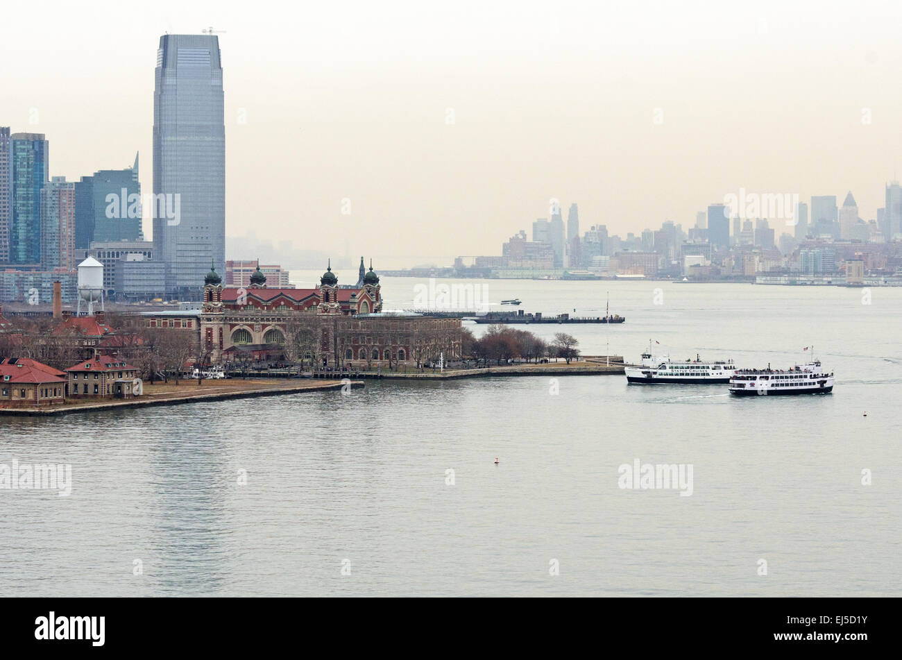 Die Gebäude der Paulus Hook von Jersey City überragen das Ellis Island Immigration Museum. Stockfoto