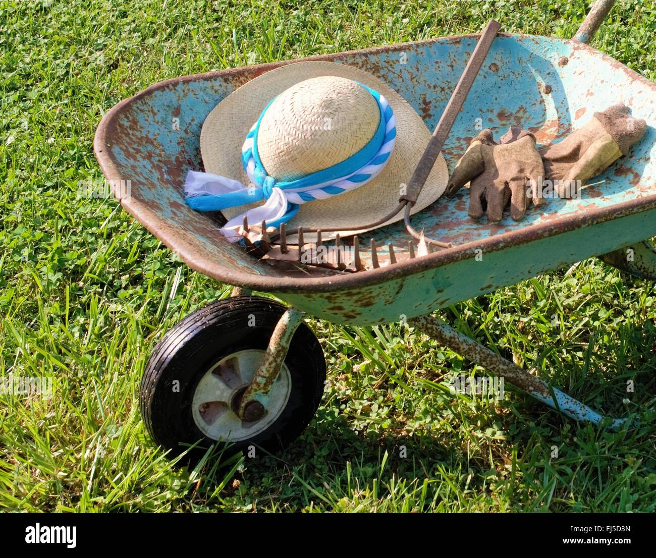 Garten Schubkarre mit Hut, Rechen und Handschuhe. Garten Werkzeuge mit