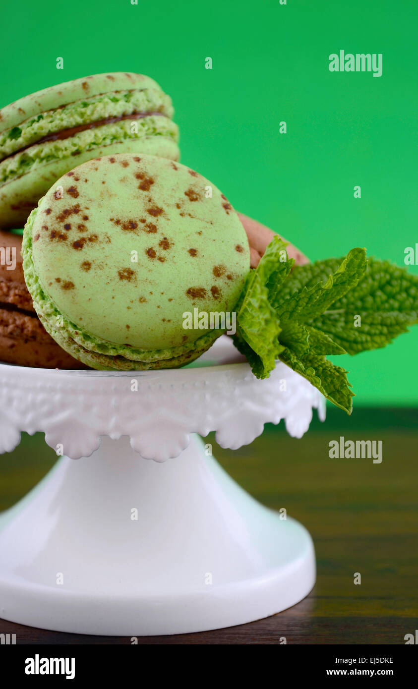 Schokolade und Minze Geschmack Makronen auf dunklen Holztisch und grünen Hintergrund. Stockfoto