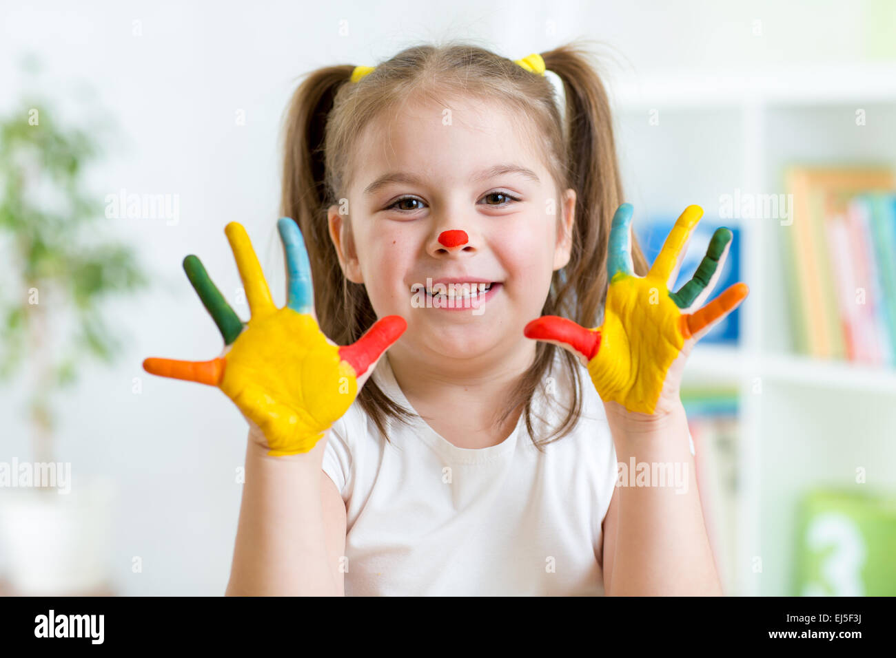 Fünf Jahre altes Mädchen mit Händen in bunten Farben lackiert Stockfoto