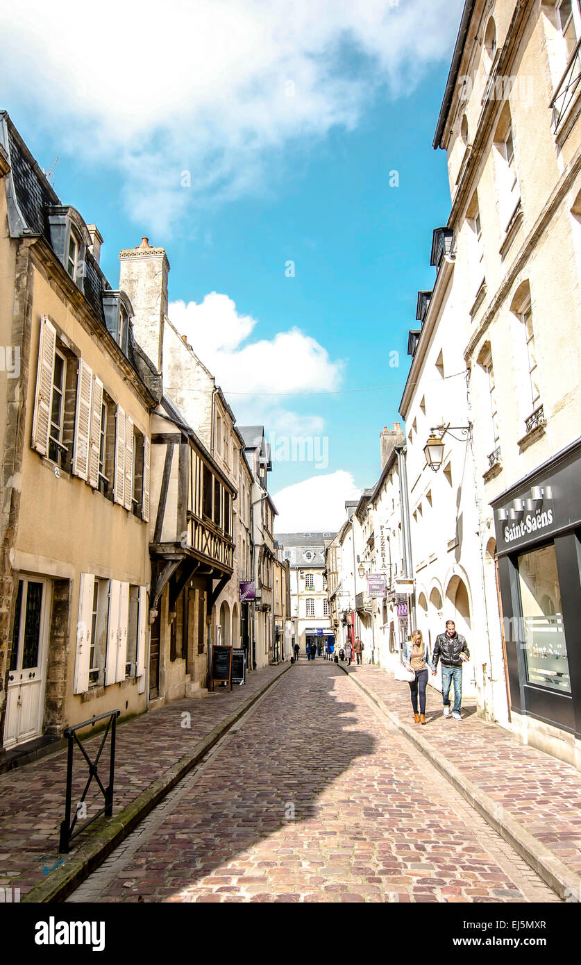 Menschen auf einer kleinen gepflasterten Straße im shopping District von Bayeux in der Normandie an einem hellen, sonnigen Tag. Stockfoto