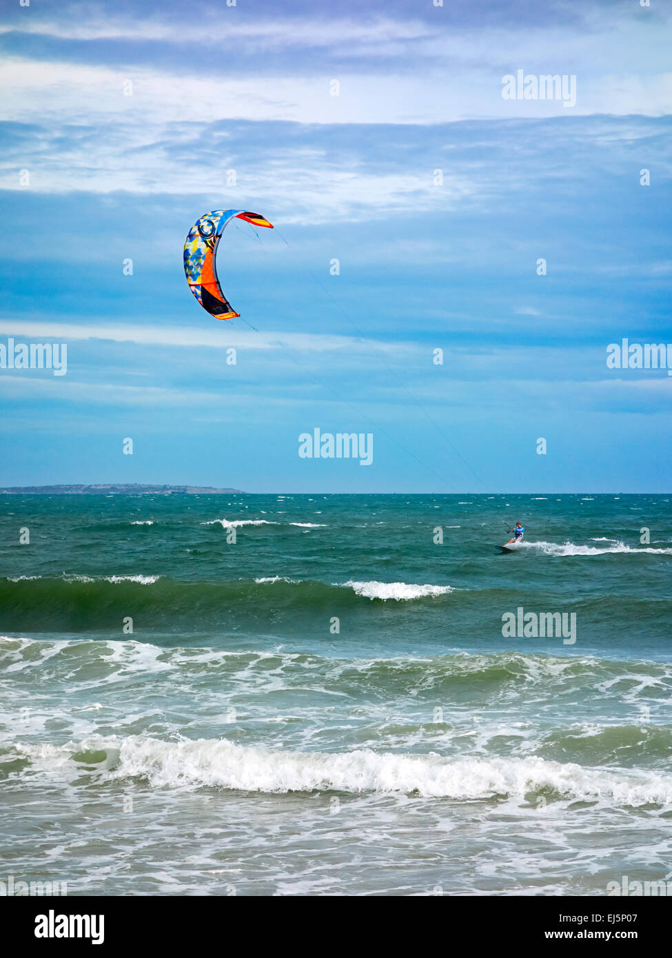 Ein Kiteboarder wird von einem Power Kite vor dem Mui Ne Strand über das Wasser gezogen. Mui Ne, Provinz Binh Thuan, Vietnam. Stockfoto