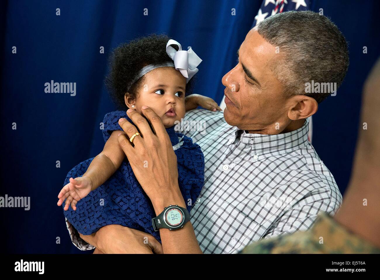 US-Präsident Barack Obama hat ein junges Mädchen beim Treffen mit Marine-Mitarbeiter und deren Familien an der Marine Corps Base Hawaii am Weihnachtstag, 25. Dezember 2014 in Honolulu, Hawaii. Stockfoto