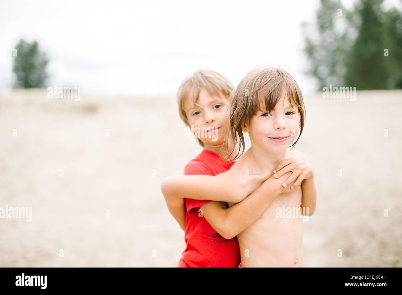 Niedliche glücklich zweieiige Zwillinge genießen ihre Zeit am Strand. Bruder und Schwester