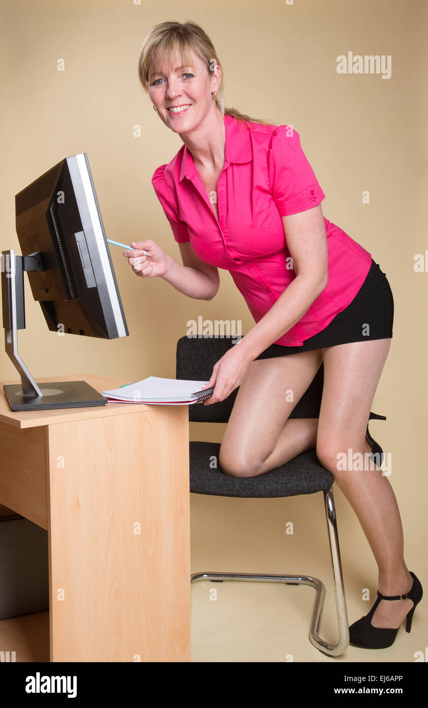 Sekretärin im Büro am Schreibtisch mit Computer-Bildschirm Stockfoto