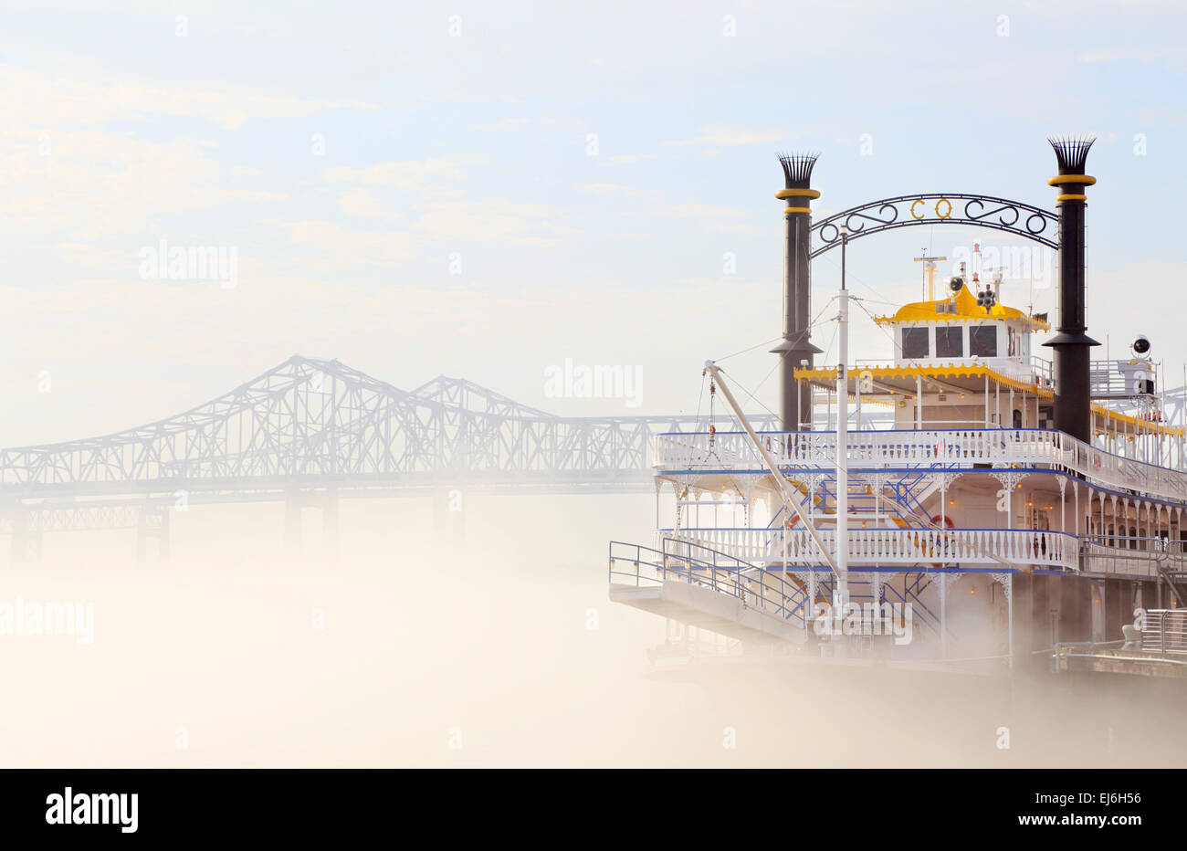 New Orleans, Louisiana. Creole Queen Cruise Ship an einem nebligen Mississippi River mit Crescent City Connection Bridge. Stockfoto