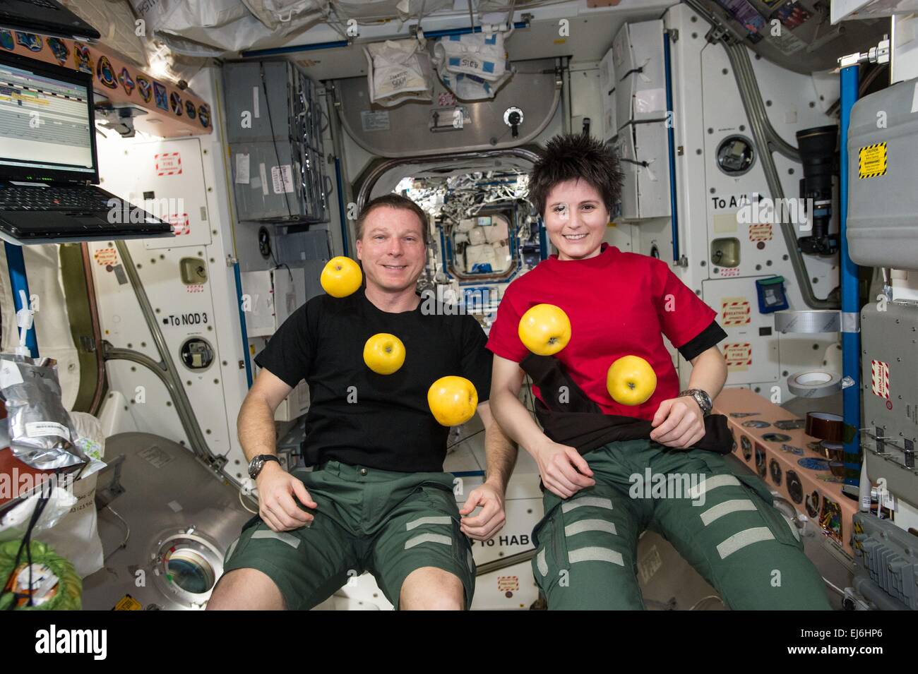 US-Astronaut Terry Virts und ESA-Astronaut Samantha Cristoforetti sehen Äpfel schweben während einer kurzen Pause von der Arbeit an Bord der internationalen Raumstation ISS 15. Januar 2015 in der Erdumlaufbahn. Stockfoto