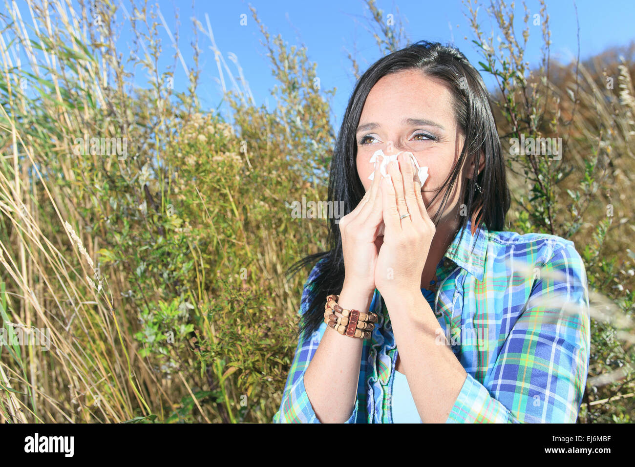 Eine junge Frau in einem Feld Niesen. Konzept: saisonale Allergie. Stockfoto