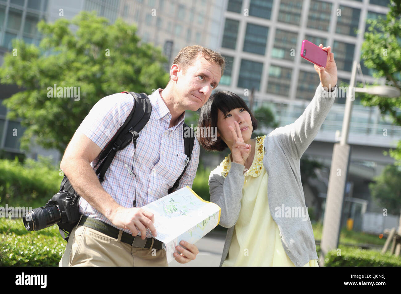 Junge japanische Mädchen nehmen Selfie mit ausländischen Touristen Stockfoto