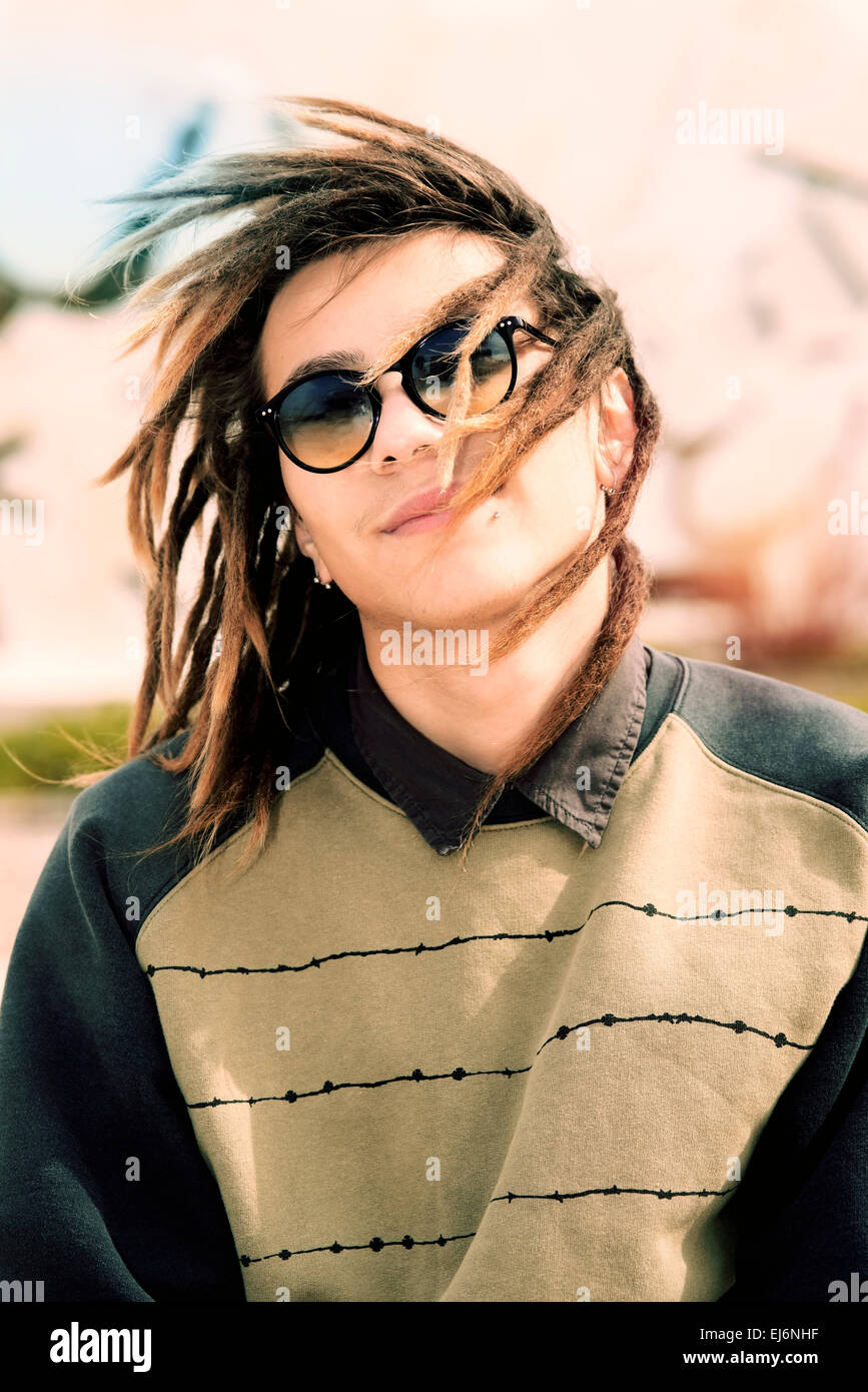 Porträt des jungen Kerl im Freien mit Rasta Haar in ein Lifestyle-Konzept mit einem warmen Filter angewendet Stockfoto