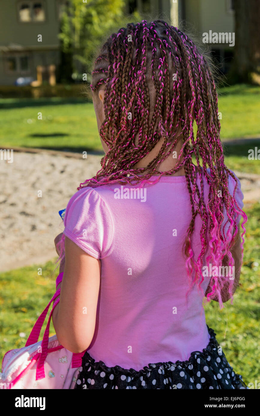 Mädchen mit rosa Schleife ins Haar geflochten. Stockfoto
