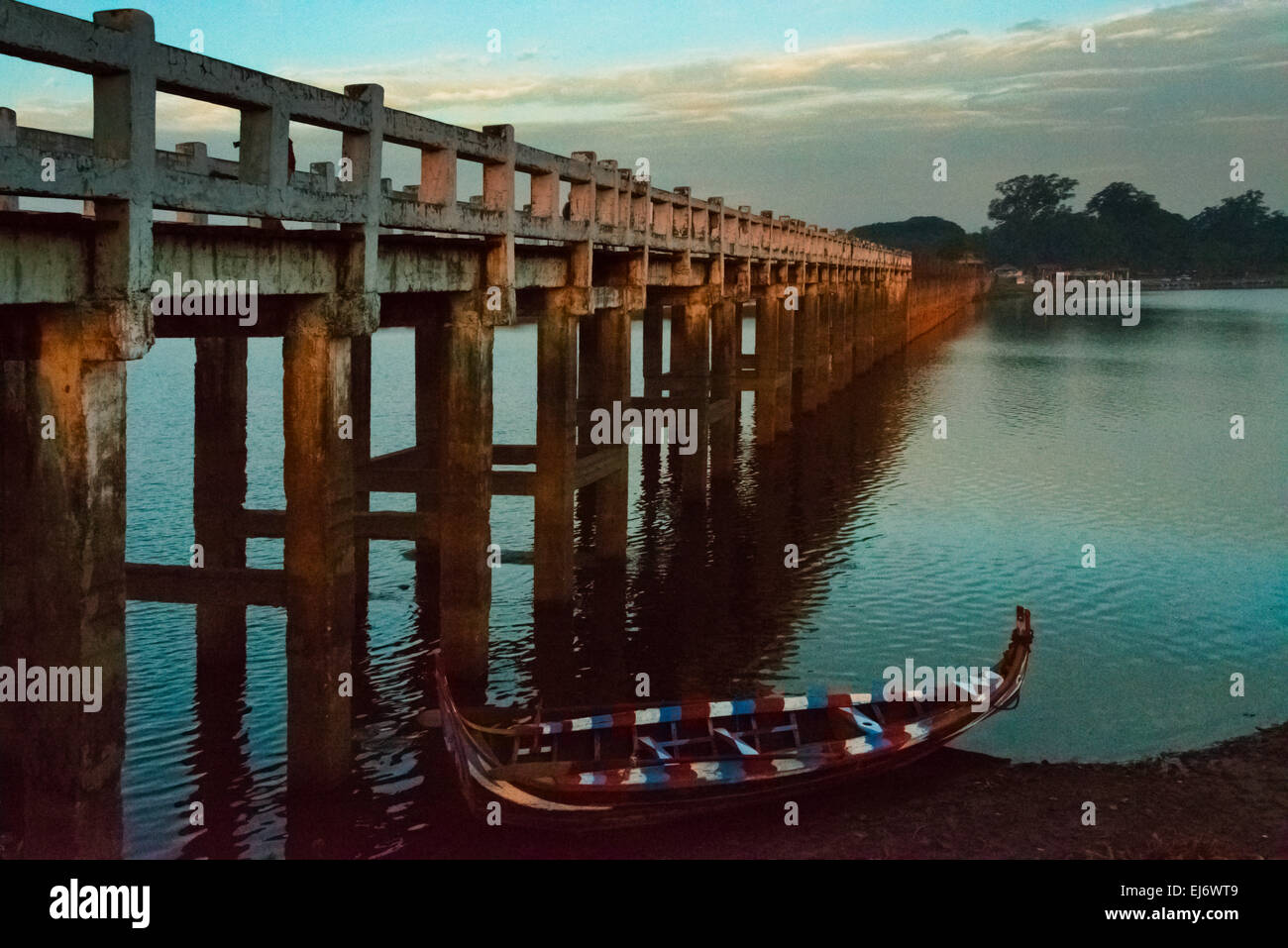 Kanu mit Amarapuras berühmten Teak U Bein Brücke auf Taungthaman See im Morgengrauen, Mandalay, Myanmar Stockfoto