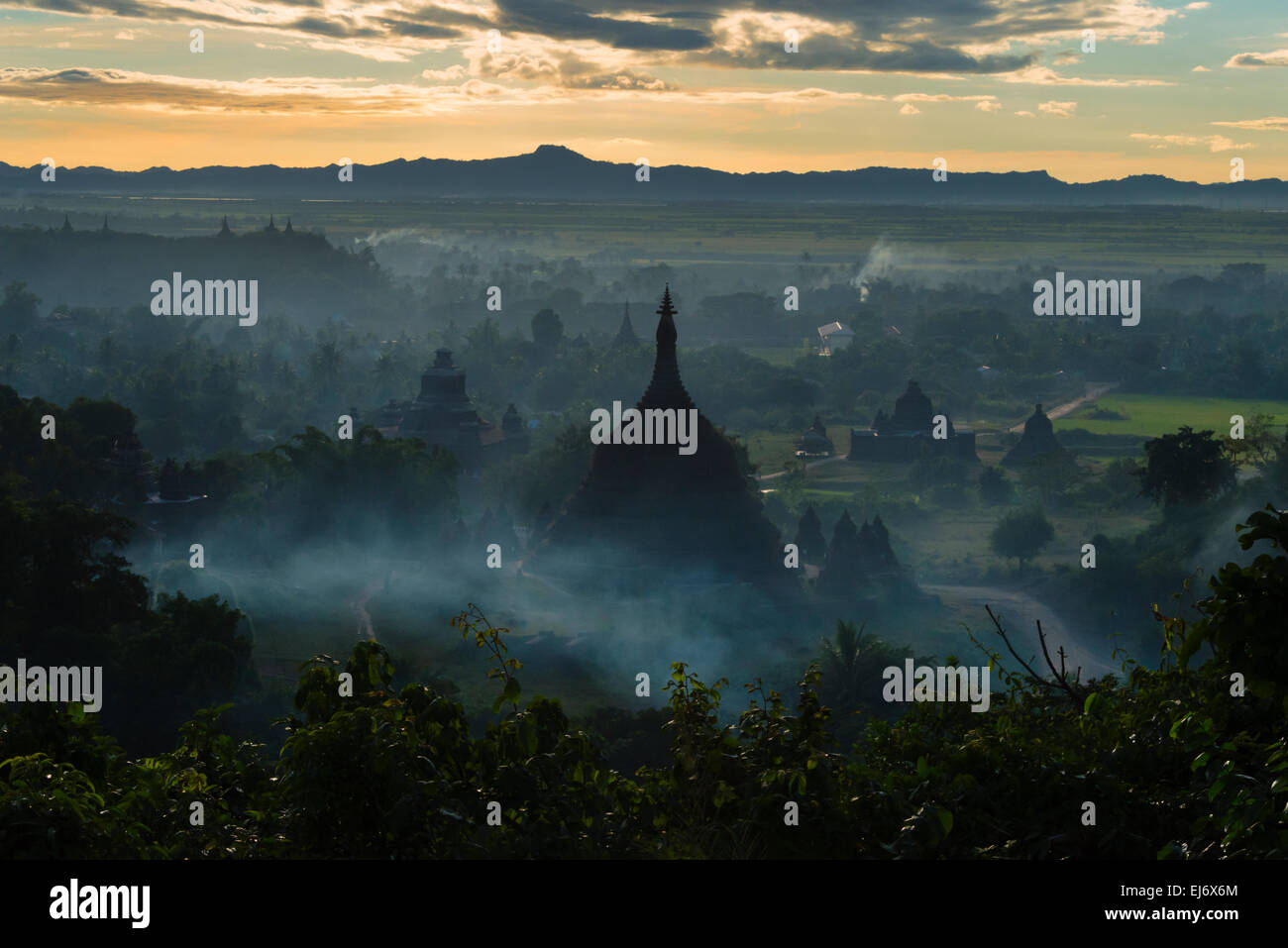 Antiken Tempeln und Pagoden in den Dschungel erhebt sich über Sonnenuntergang Nebel, Mrauk-U, Rakhine State in Myanmar Stockfoto