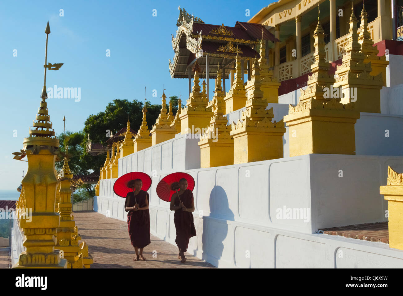 Mönche mit roten Regenschirm in Umin Thounzeh Pagode, Sagaing Hill, Mandalay, Myanmar Stockfoto