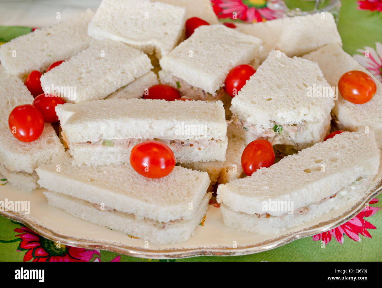 Crustless Thunfisch-Sandwiches mit Trauben Tomaten auf einem Teller für einen Nachmittagstee oder Mittagessen setzen. Stockfoto
