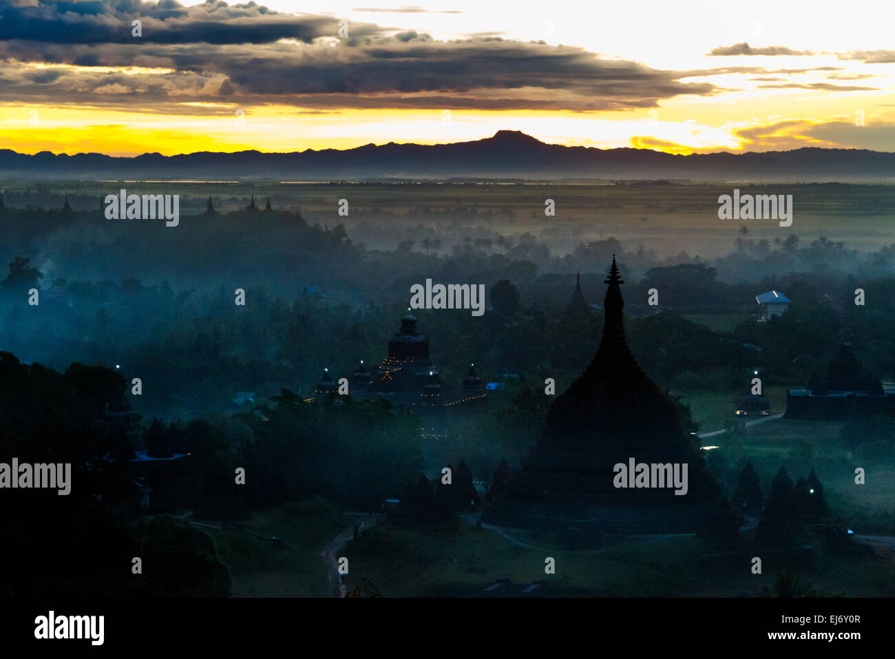 Antiken Tempeln und Pagoden in den Dschungel erhebt sich über Sonnenuntergang Nebel, Mrauk-U, Rakhine State in Myanmar Stockfoto