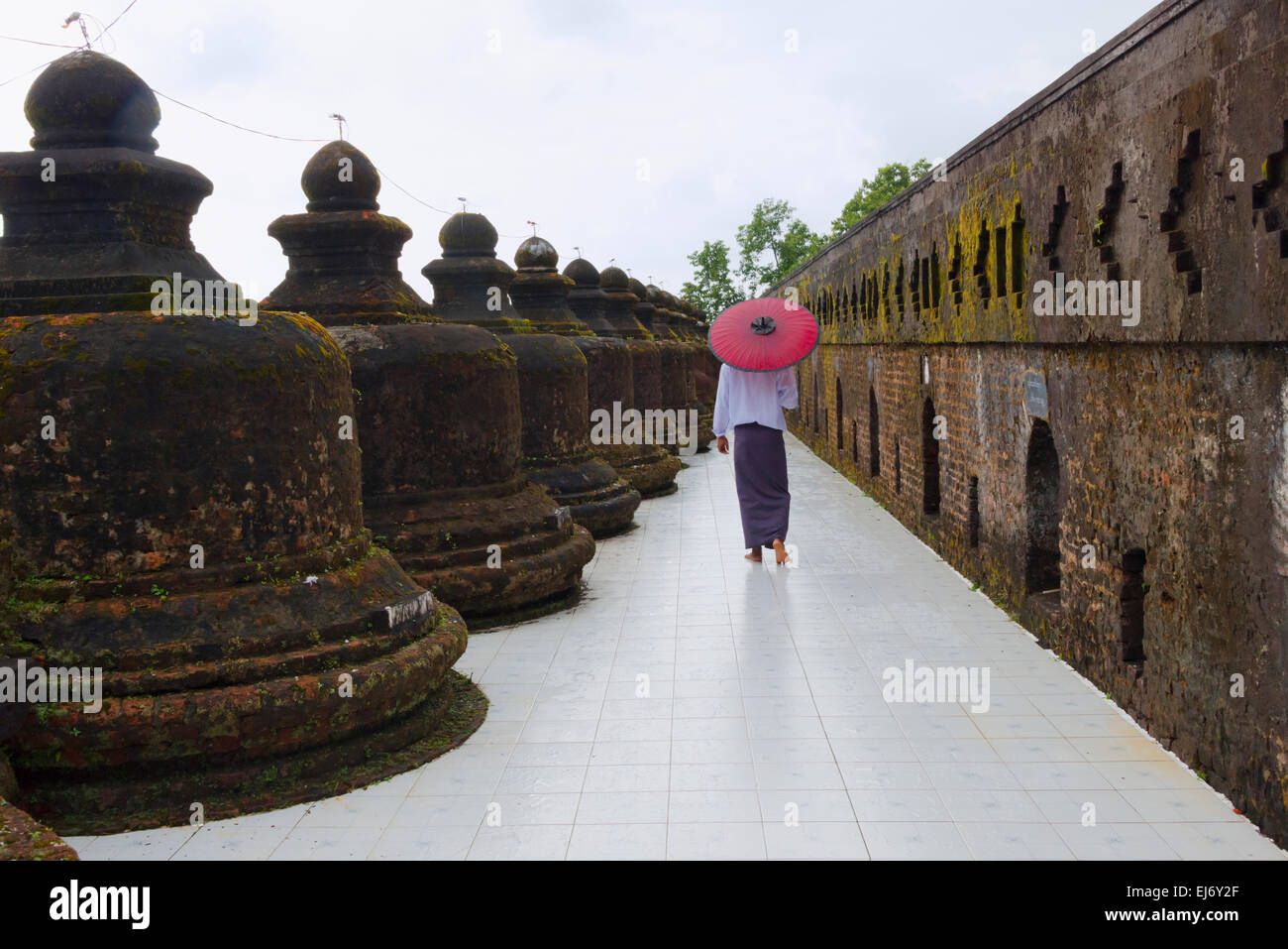 Mann mit Schirm in Htukkanthein (Dukkhanthein) Tempel, erbaut von König Min Phalaung, Mrauk U, Rakhine State in Myanmar Stockfoto