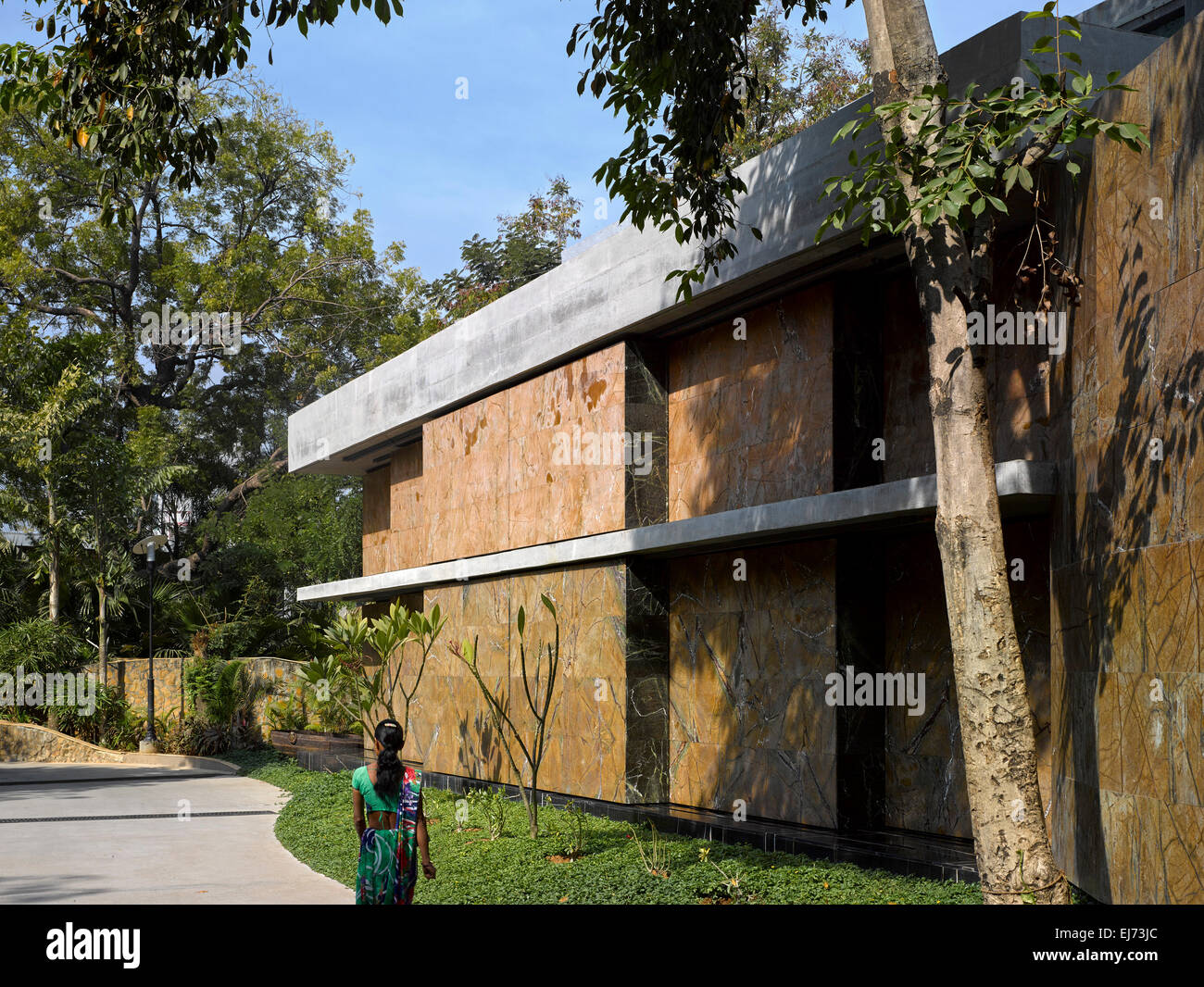 Alles in allem Außenansicht vom Haupteingang mit vorbeifahrenden Figur. Haus mit Mauern, Ahmedabad, Indien. Architekt: Matharoo associates Stockfoto