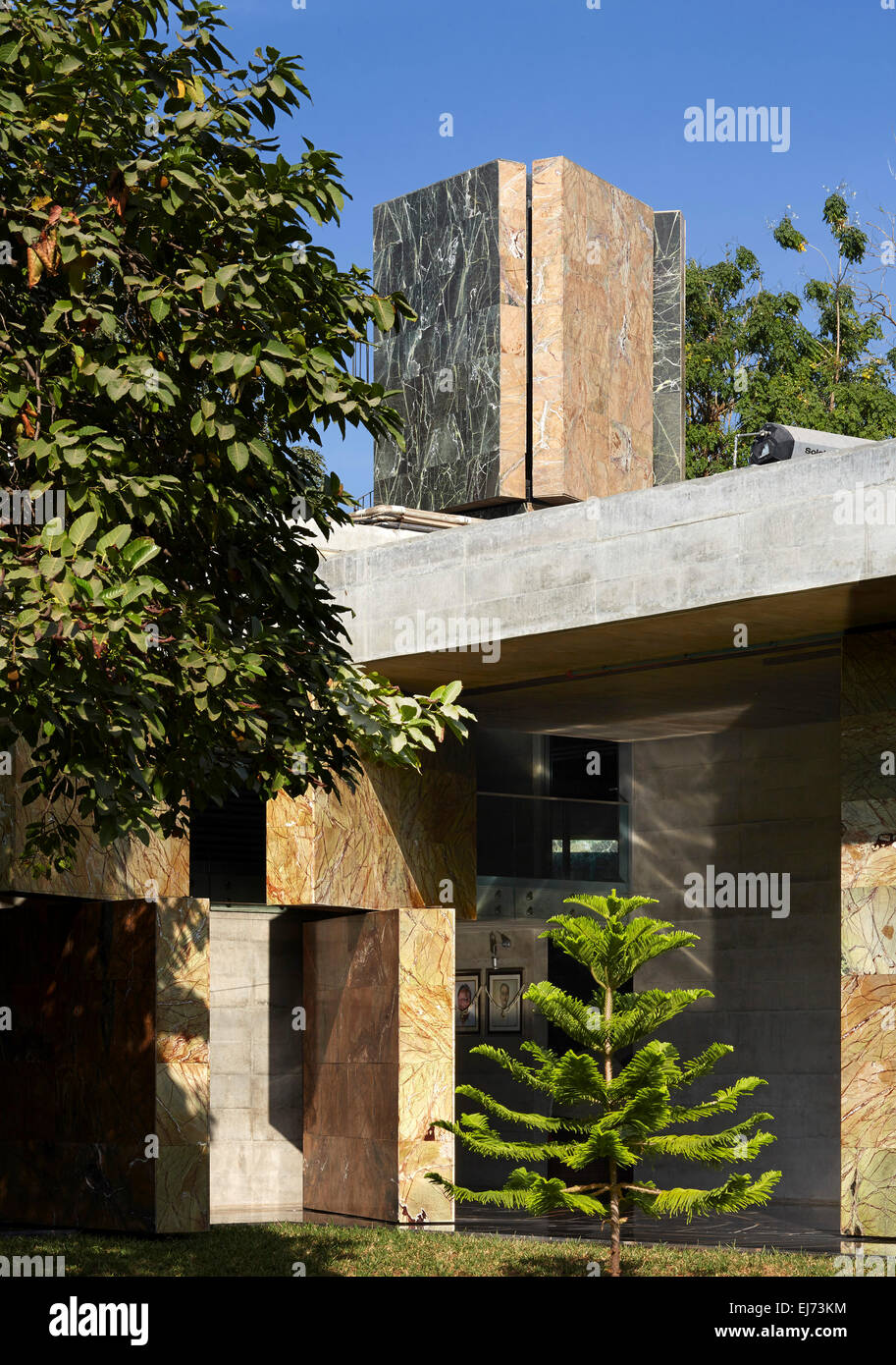 Blick vom Garten zeigt Wände und Wasserturm. Haus mit Mauern, Ahmedabad, Indien. Architekt: Matharoo associates, 2015. Stockfoto