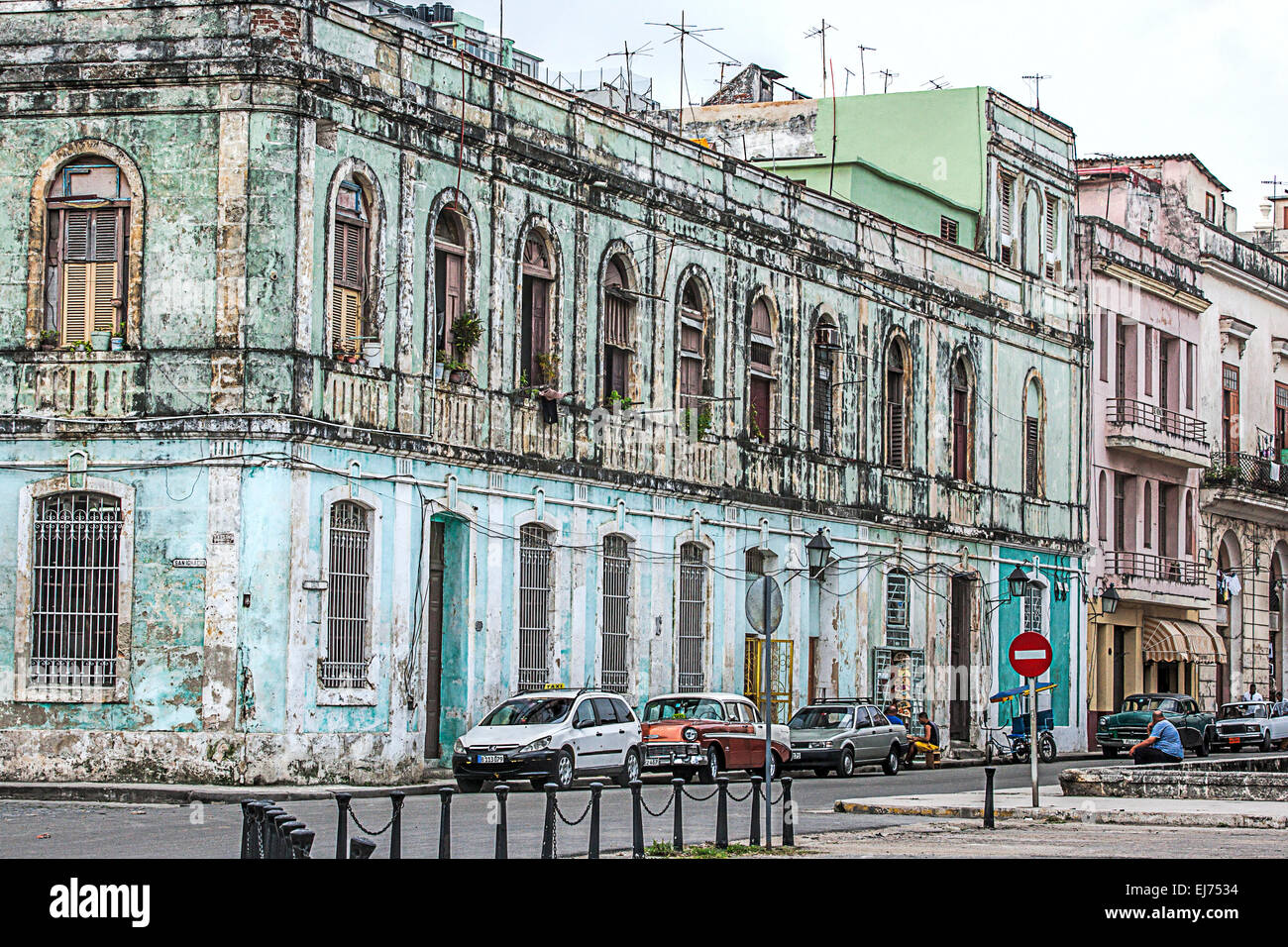 Prächtige Straßenszene in Alt-Havanna mit einem Gebäude in der hoffnungslosen Notwendigkeit der Reparatur und dem alten amerikanischen Autos auf der Straße geparkt Stockfoto