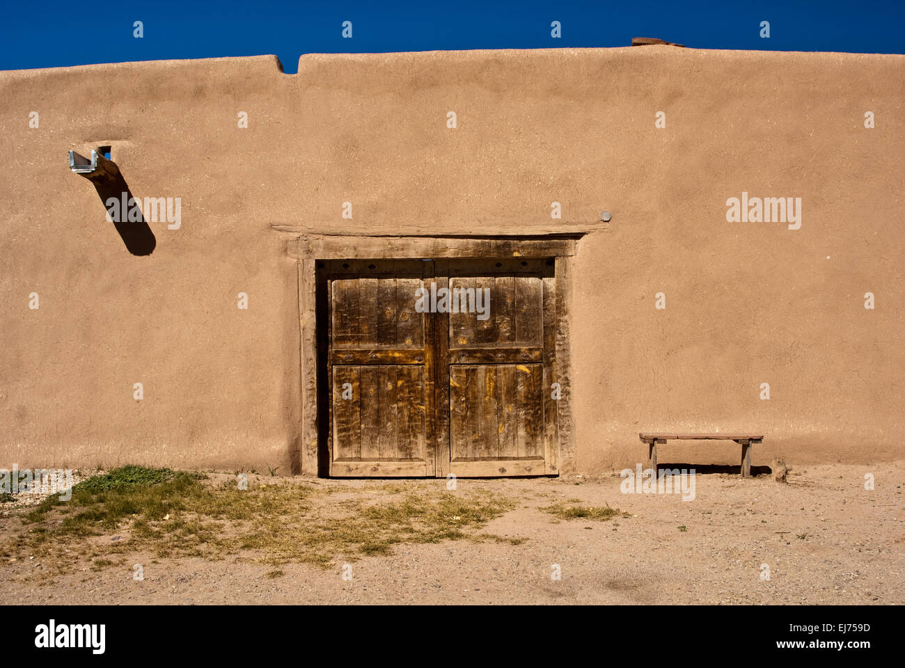 Adobe Gebäude mit alten Tür und Bank Stockfoto