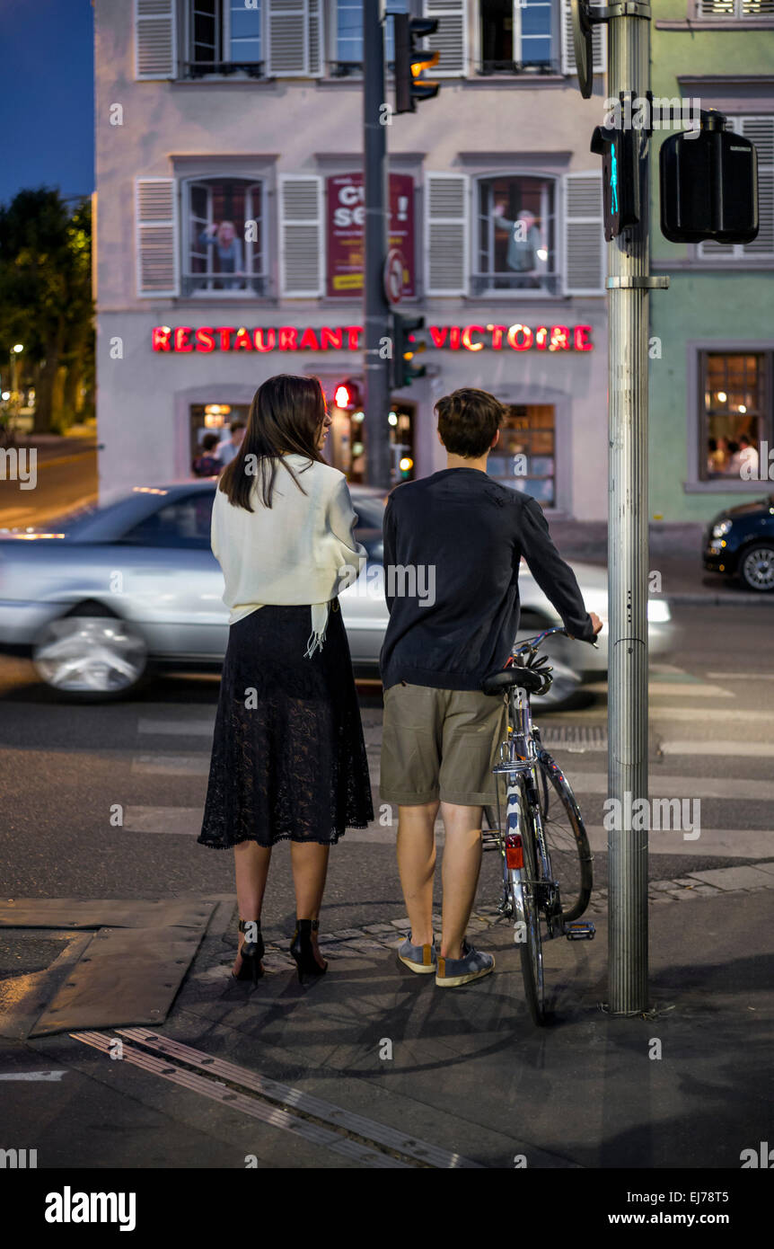 Junges Paar warten an Fußgängerübergang, Auto, Nacht Strasbourg Elsass Frankreich Europa Stockfoto