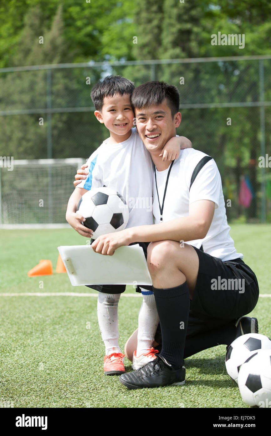 Der junge umarmte Trainer im Fußball Stockfoto