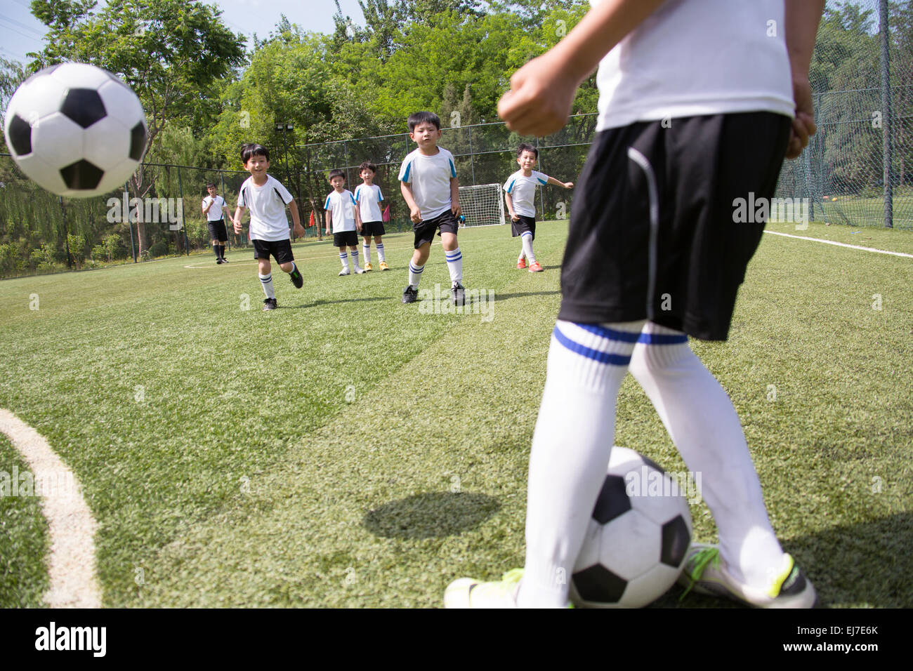 Die Jungs Fußball spielen auf dem Spielplatz Stockfoto