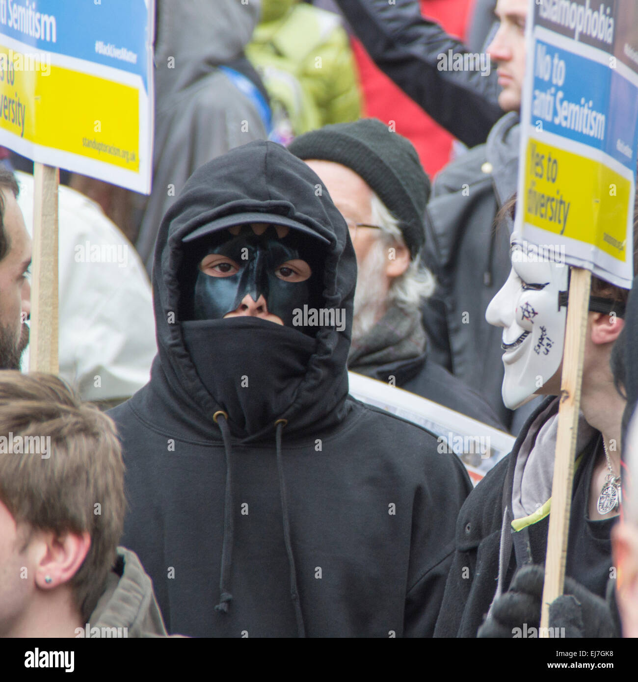 Piccadilly Circus, London, Großbritannien - 21. 2015. März: Schwarz gekleidet ein maskierter Protestler in der Menge auf der Demonstration gegen Rassismus und Faschismus. Stockfoto