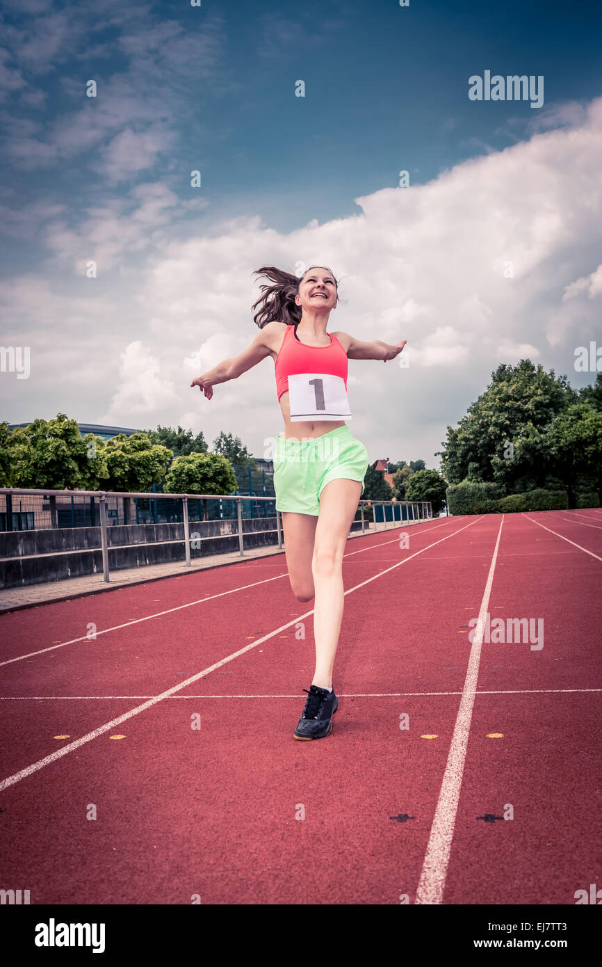 weibliche athletische Sportlerin auf einer Strecke im Stadion Stockfoto