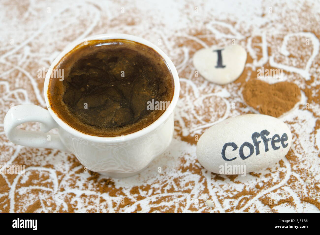 Weiße Tasse Kaffee und Felsen sagen: "Ich liebe Kaffee" Stockfoto