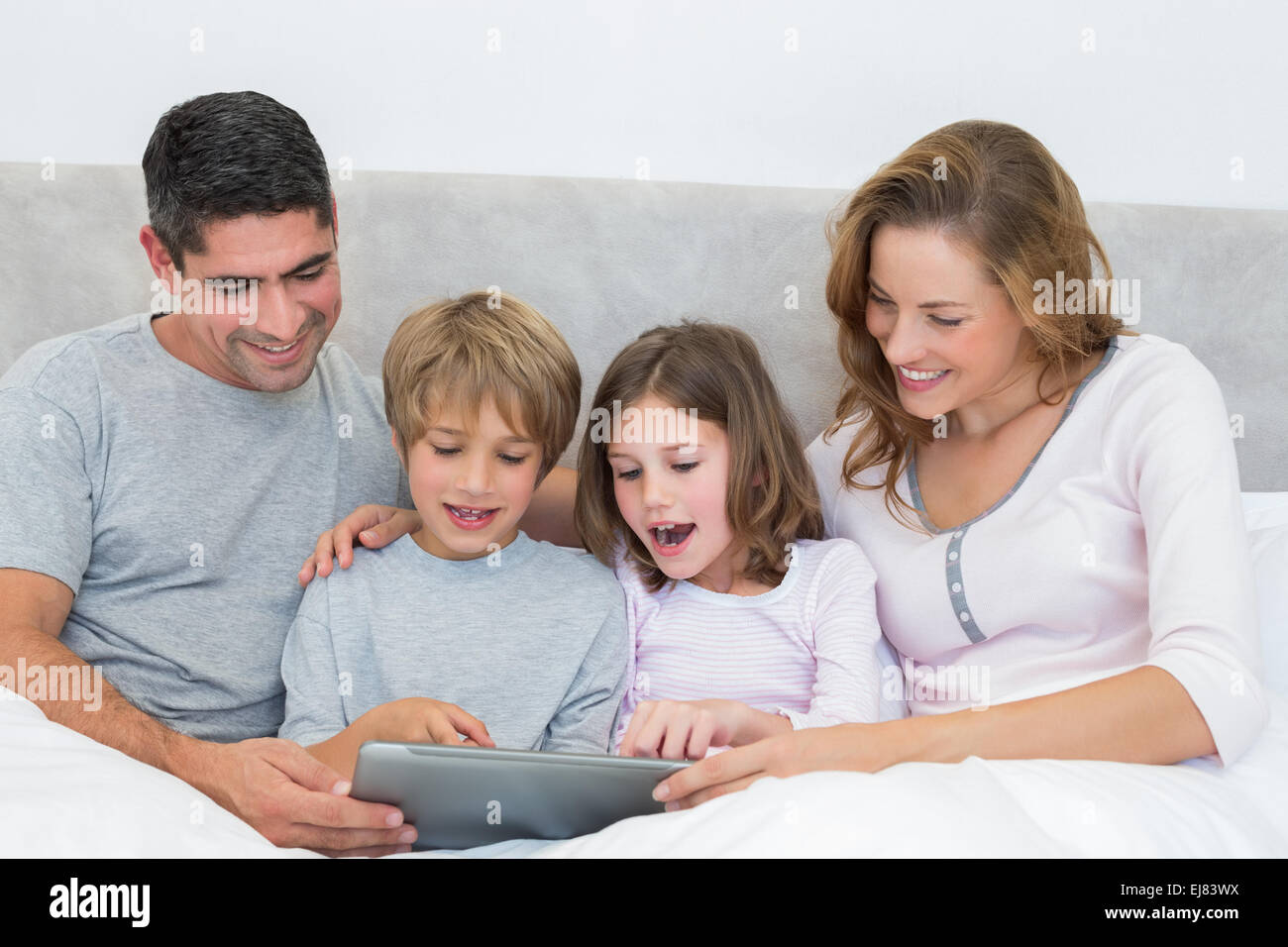 Familie mit Hilfe von digital-Tablette im Bett Stockfoto