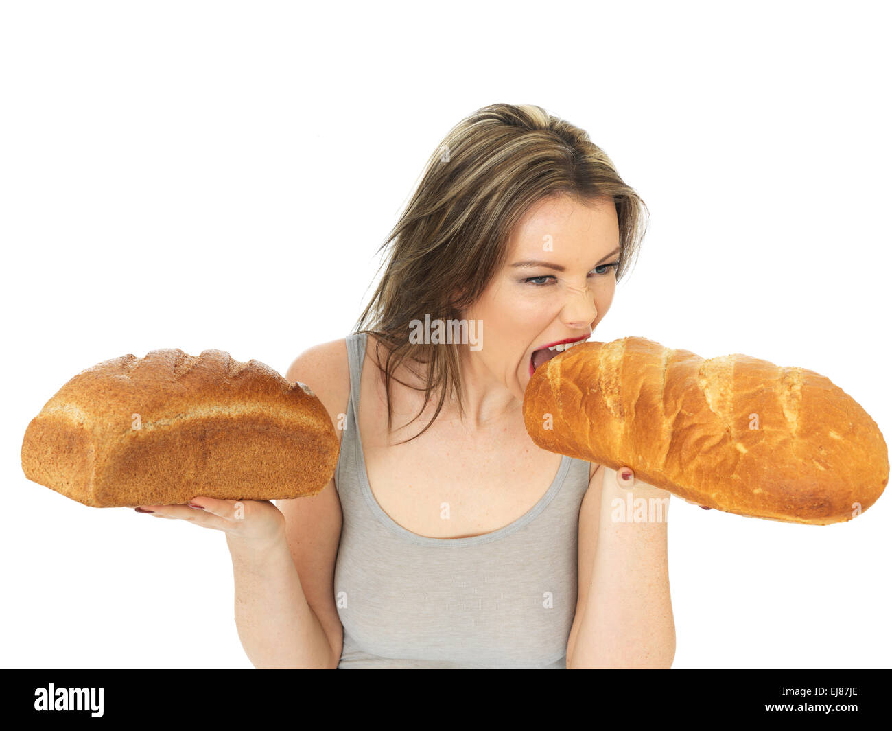 Attraktive junge Frau, die weiße und braune Brot vergleichen Stockfoto