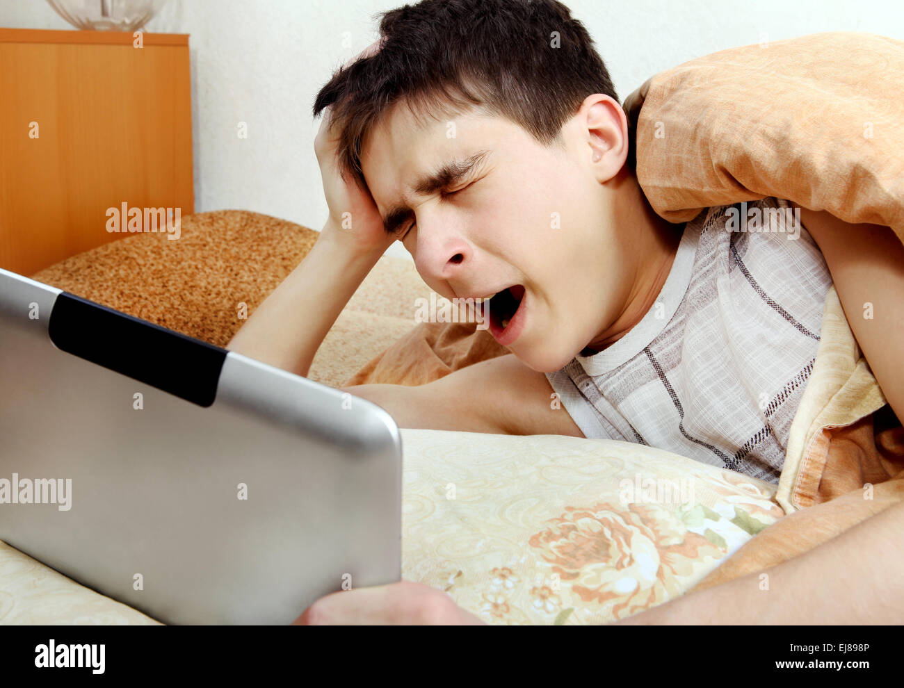 Müde Teenager mit Tablet-Computer Stockfoto