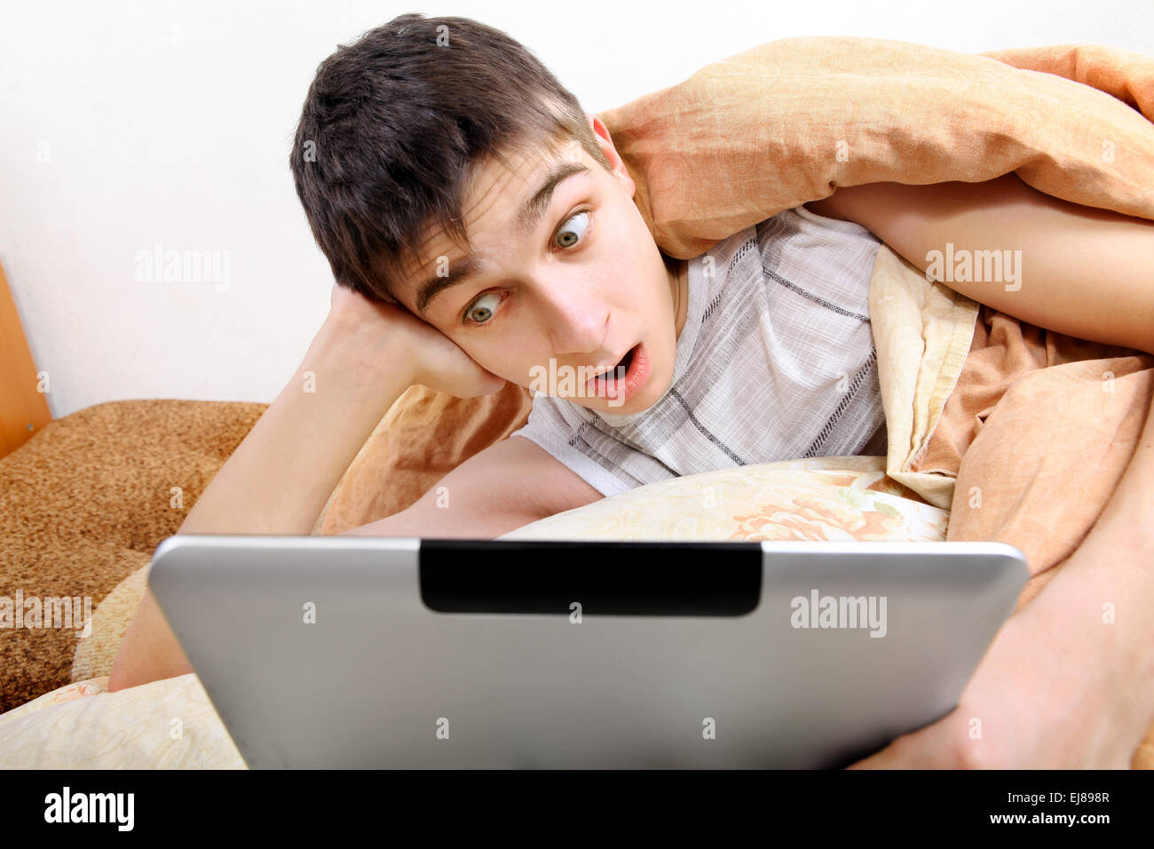 Überrascht Teenager mit Tablet-Computer Stockfoto