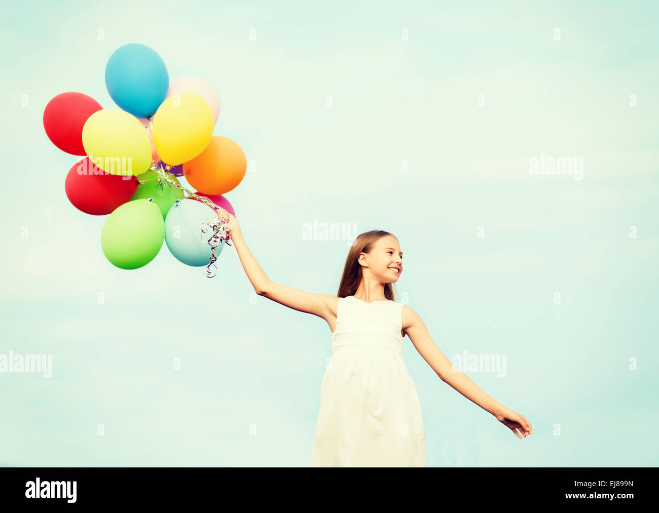 glückliches Mädchen mit bunten Luftballons Stockfoto