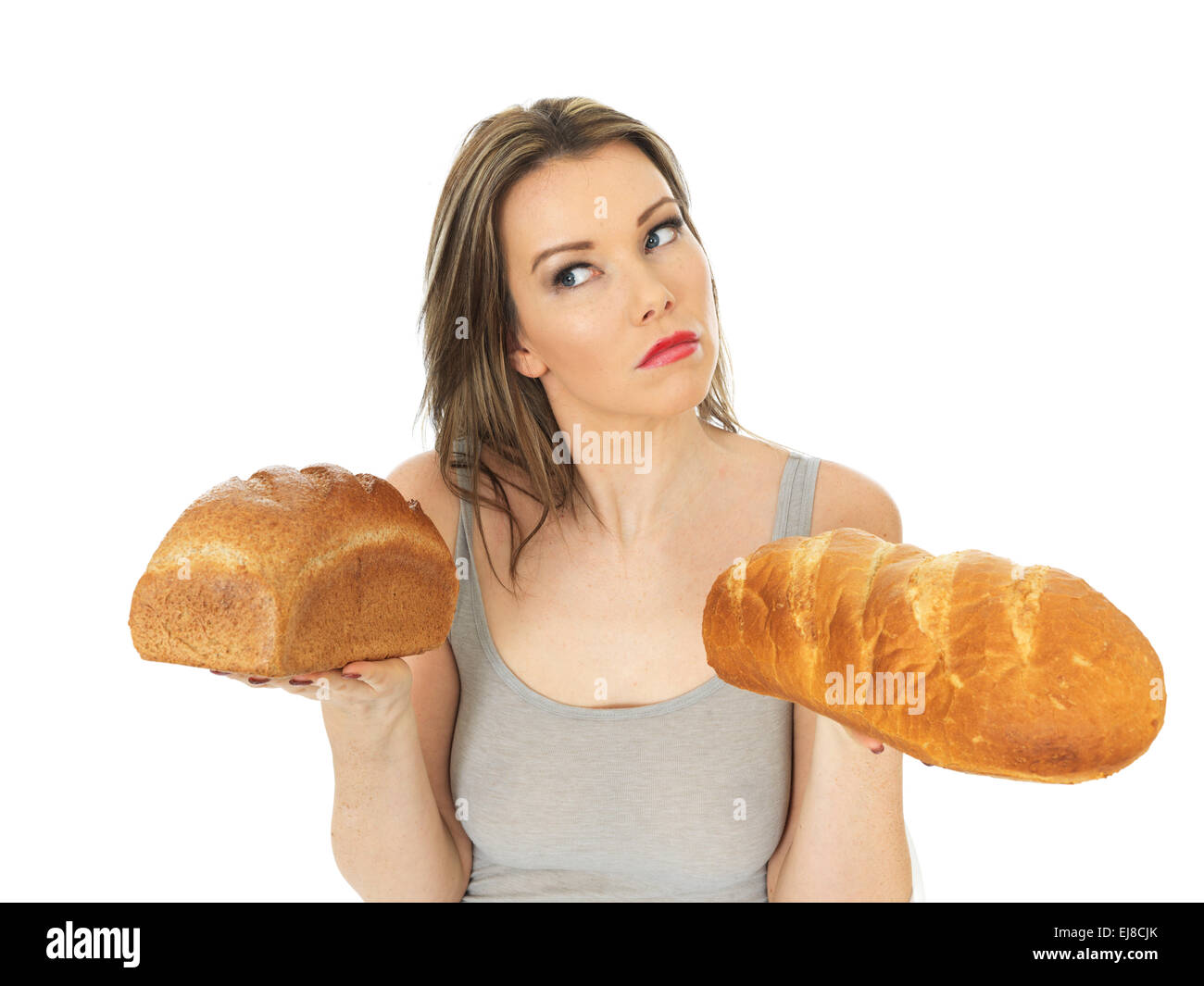 Attraktive junge Frau, die weiße und braune Brot vergleichen Stockfoto