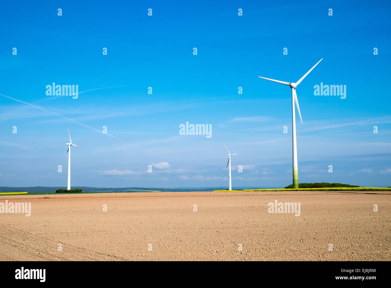 Windräder hinter einem unfruchtbaren Feld Stockfoto