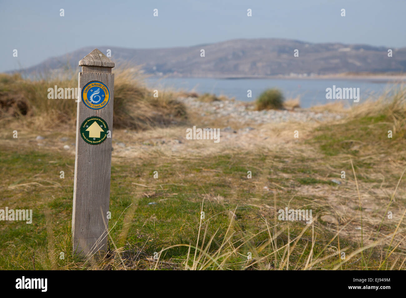 Hölzerne Wegpunkt / post auf dem Küstenpfad von Wales auf Sand Dünen / Strand bei Conwy, Nordwales mit Blick auf Llandudno und Meer Stockfoto