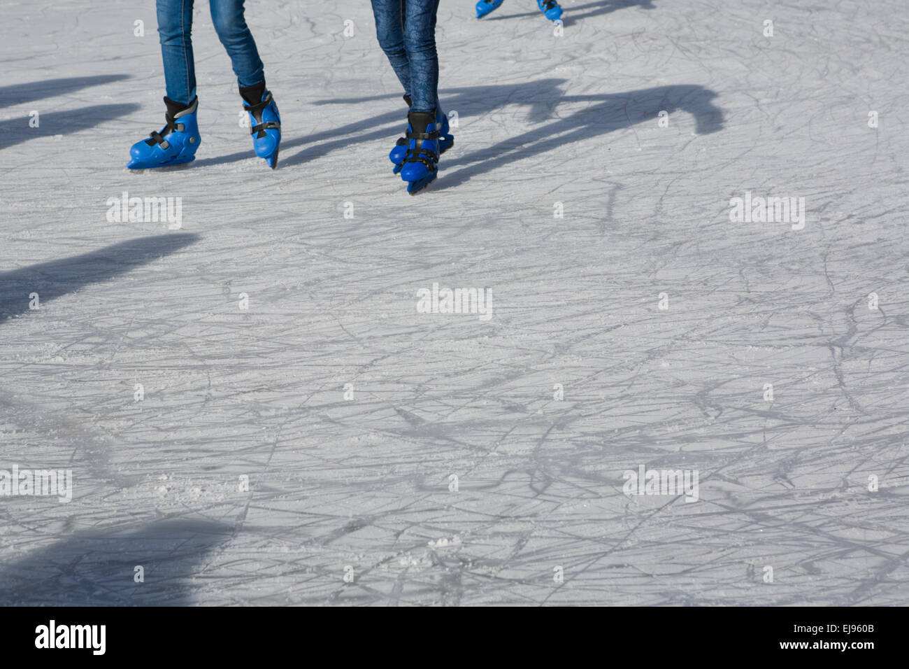 Menschen Schlittschuh laufen zusammen im Freien, zusammen mit ihre Schatten Stockfoto