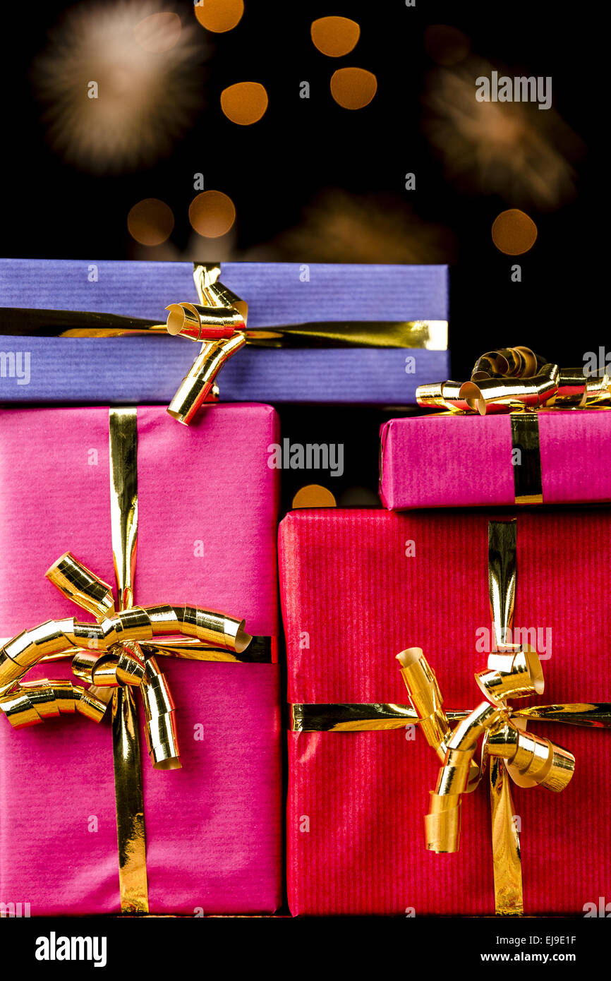 Vier einfarbige Geschenke mit goldenen Bögen Stockfoto
