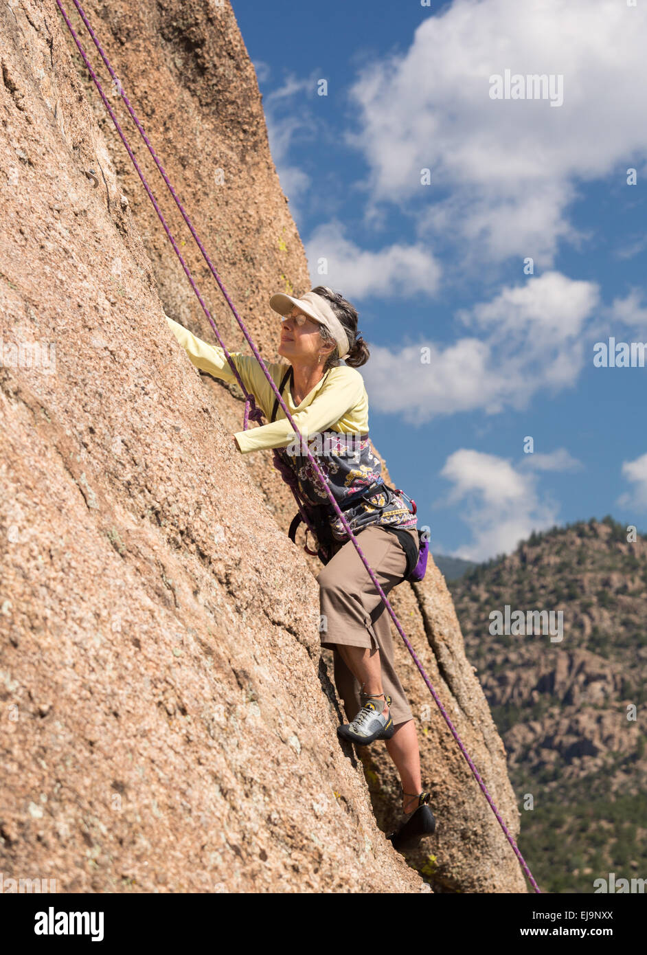 Ältere Dame auf steilen Felsen klettern in Colorado Stockfoto