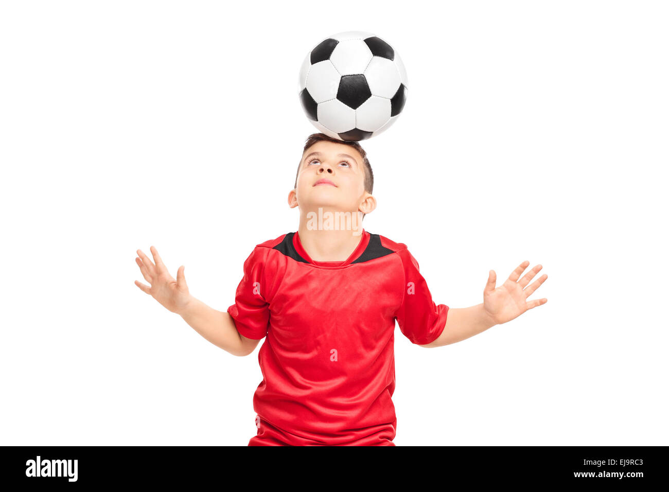 Junior Fußball-Spieler tragen rote Hemd joggling mit einem Fußball isoliert auf weißem Hintergrund Stockfoto