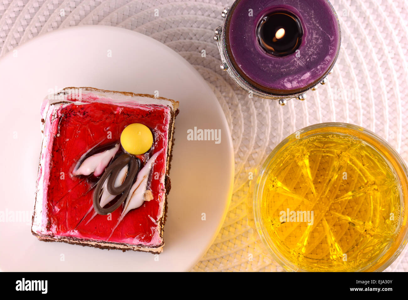 süße Kuchen auf weißen Teller mit Wein und Kerze Stockfoto