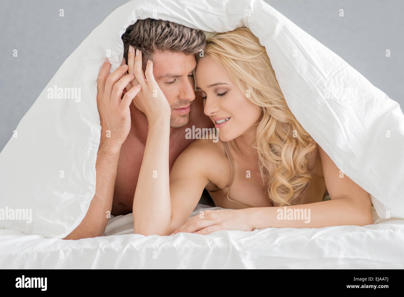Süßes junges Paar auf Bett-Mode-Shooting Stockfoto