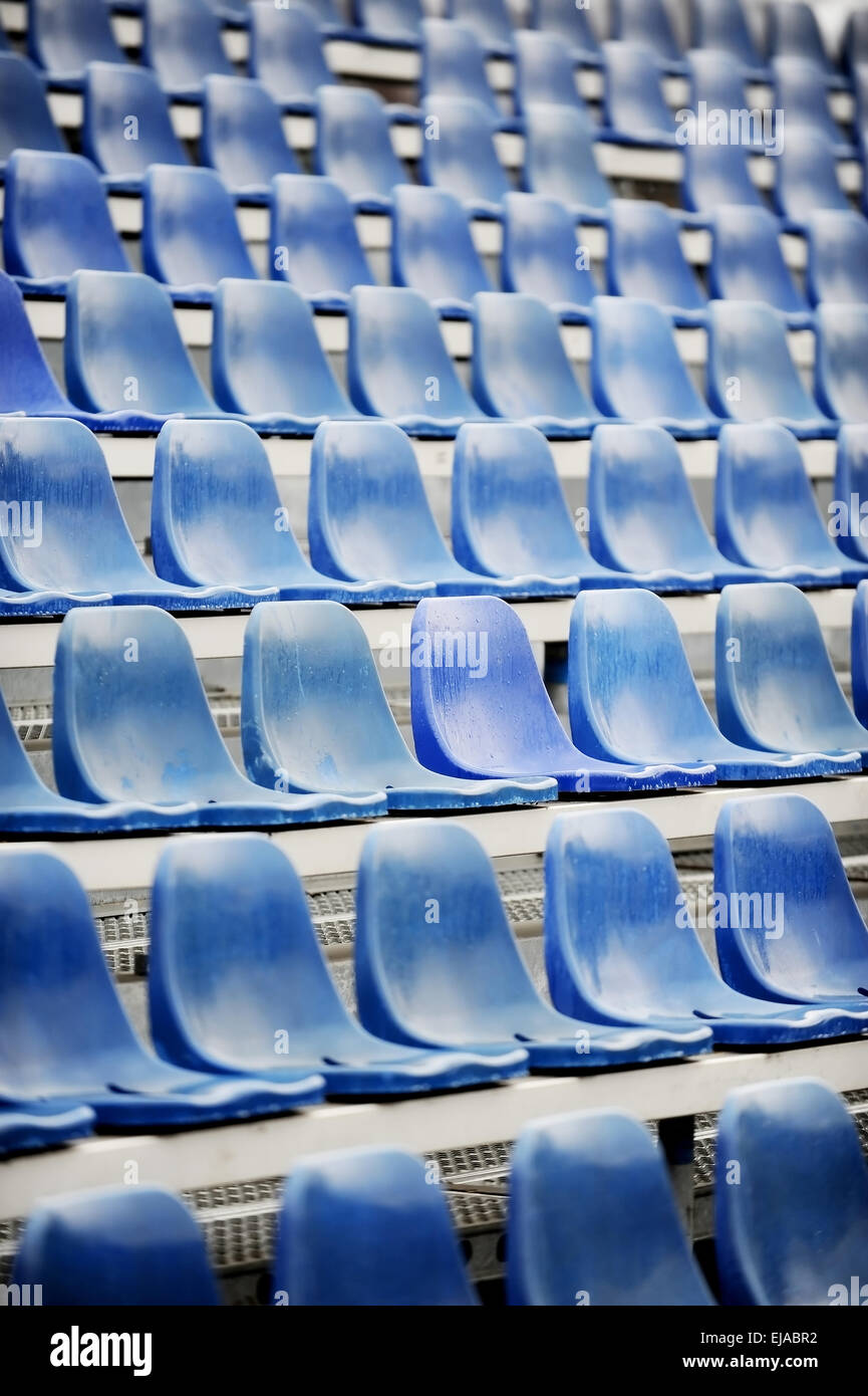 Leere blaue Sitze auf Sport-Arena-Tribüne nach dem Regen Stockfoto