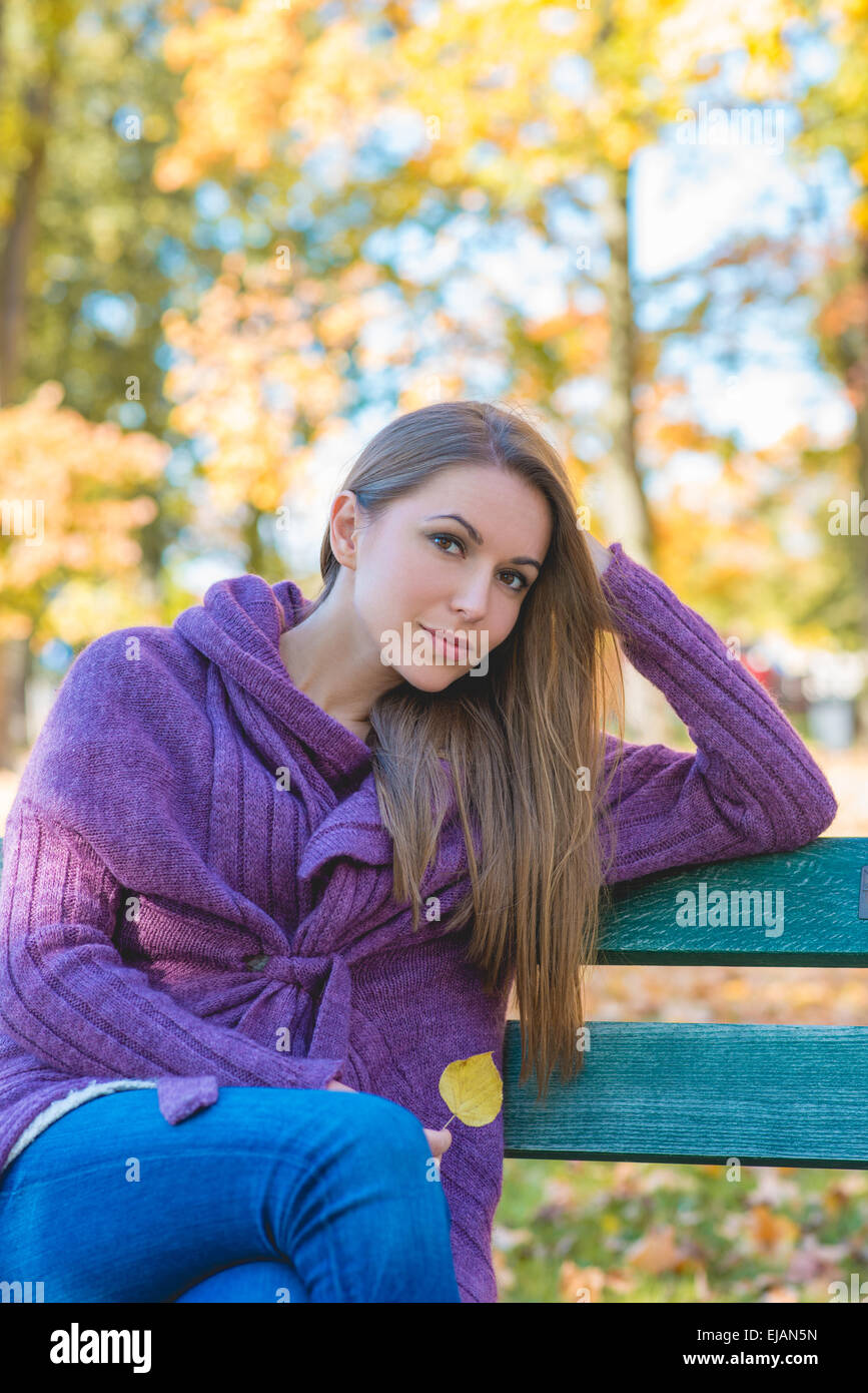 Nachdenkliche Frau entspannend in einem herbstlichen park Stockfoto