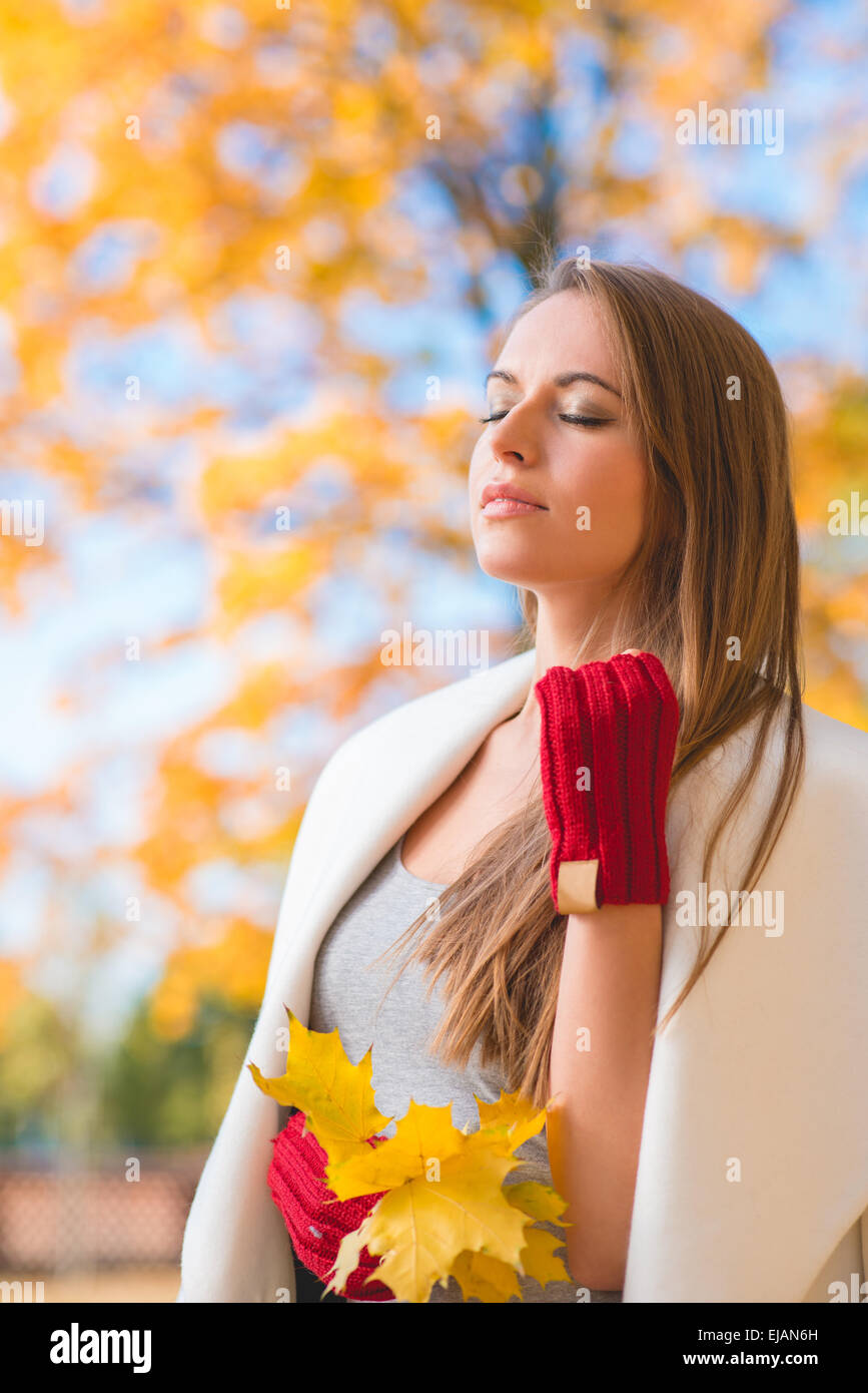 Junge Frau, die die Schönheit des Herbstes genießen Stockfoto