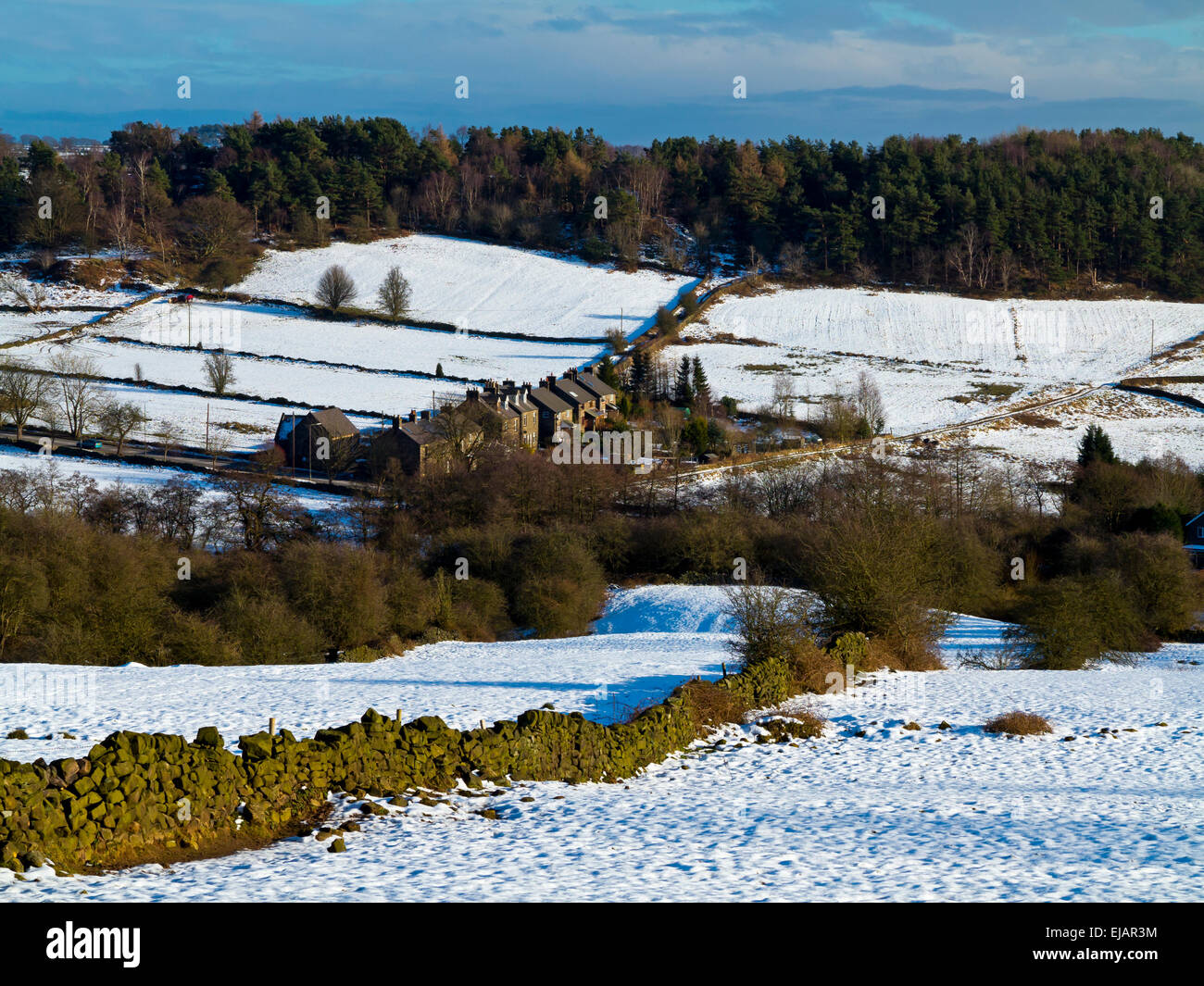 Verschneite Winterlandschaft in der Nähe von Matlock im Peak District Derbyshire Dales England UK mit Reihenhäusern und Trockenmauer Stockfoto