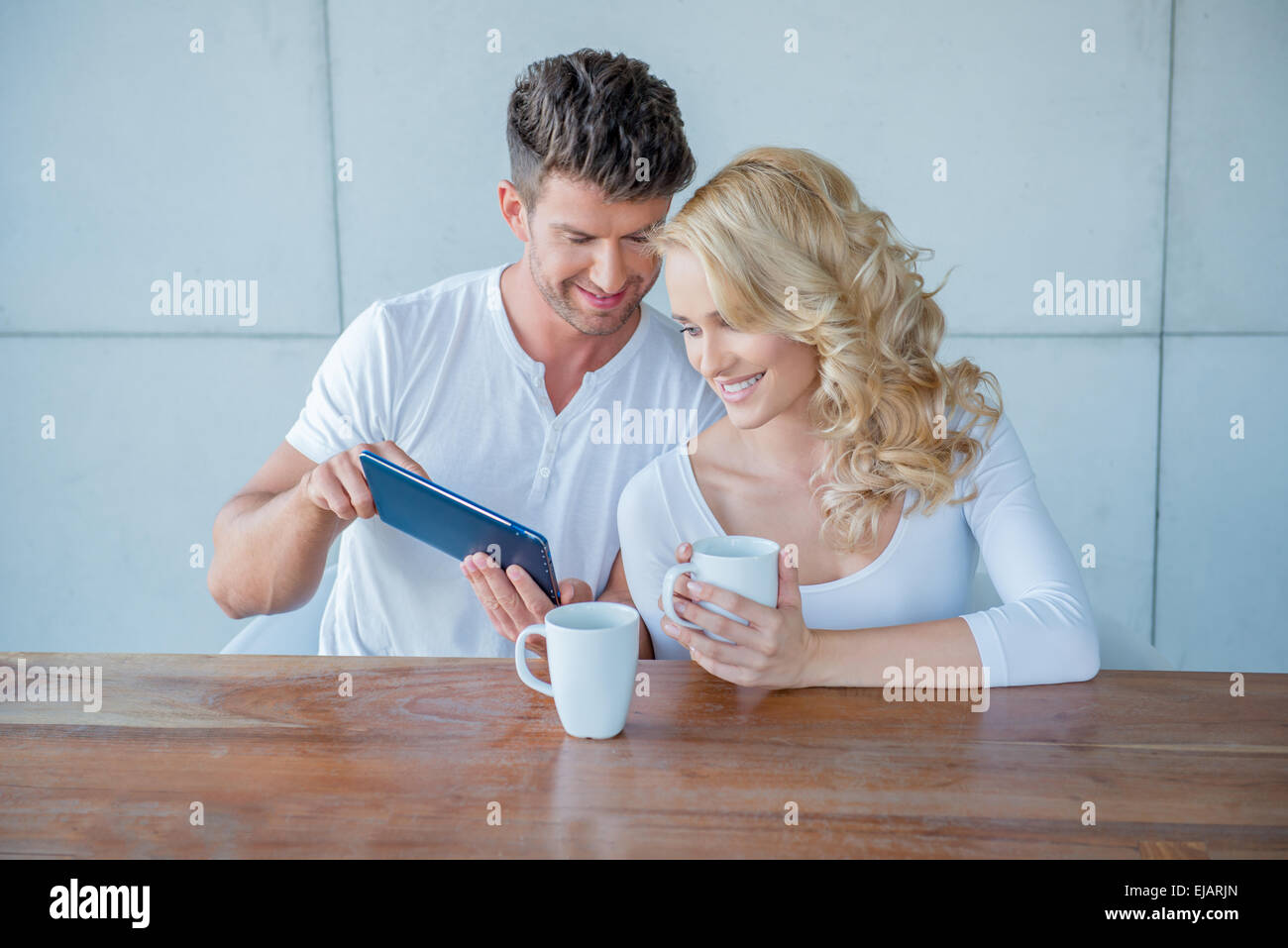 Mann zeigt seine Frau etwas auf einem tablet Stockfoto